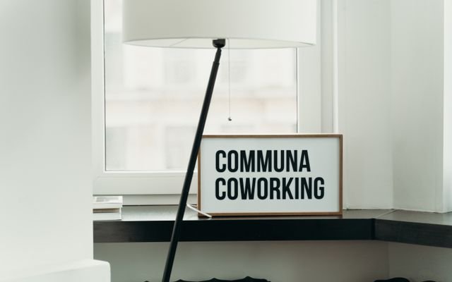 Simple and elegant coworking space decor with soft lamp lighting and window view.