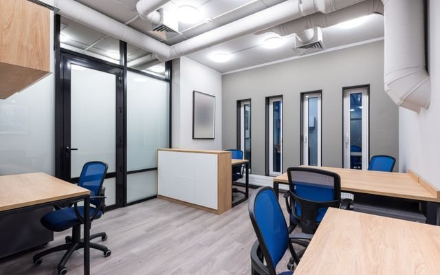 Interior of new contemporary spacious workplace with wooden desks and blue office chairs