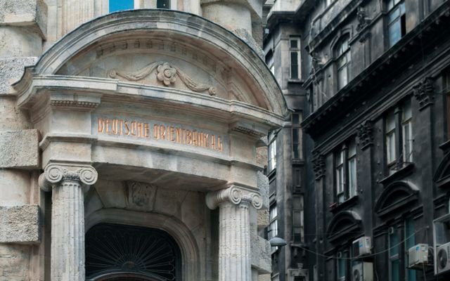 Deutsche orient bank in historical building with engraved elements and concrete columns on street near residential house in city of Istanbul