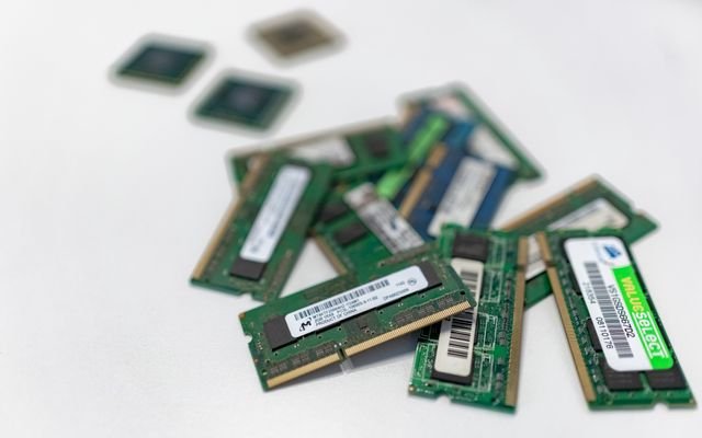 Assorted RAM modules scattered on a white surface, showcasing technology components.
