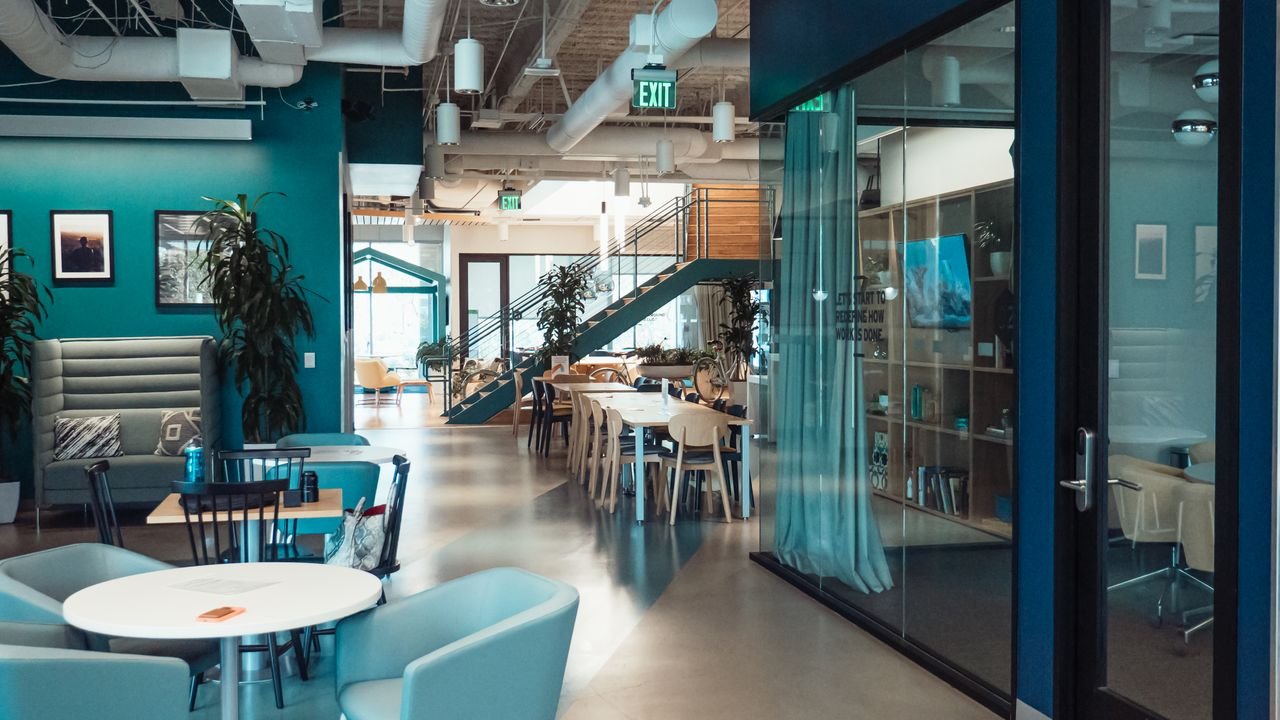 Open and collaborative modern office space with stylish furniture and natural lighting.