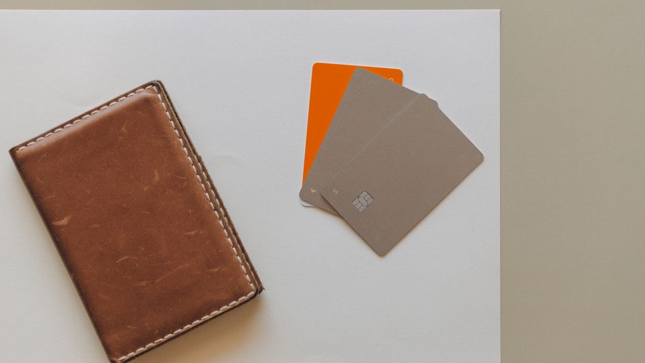 A leather wallet and credit cards on a minimalist background, ideal for financial themes.