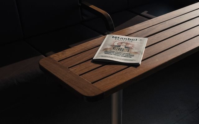 From above of empty dark chairs and closed book about Turkey placed on wooden dark brown table