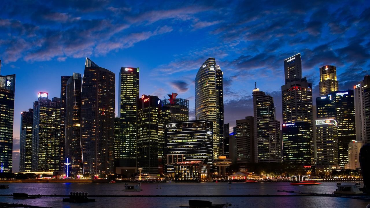 Spectacular view of Singapore's skyline with illuminated skyscrapers against a twilight sky.