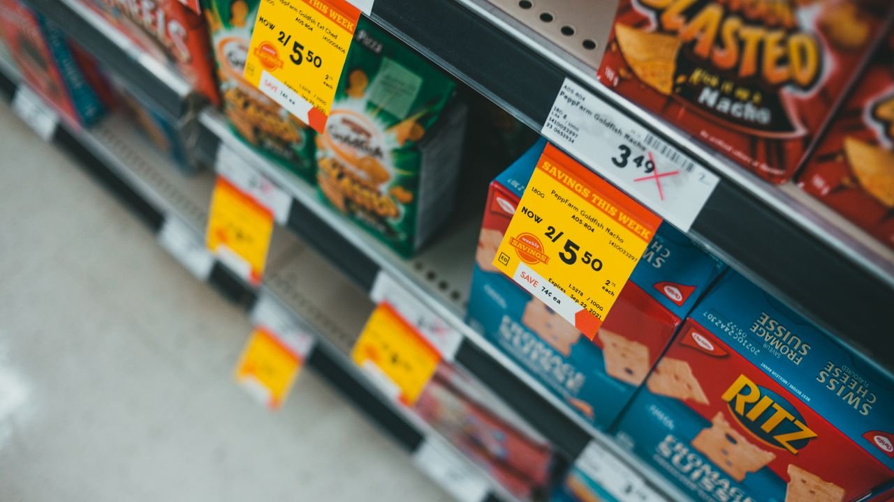 Supermarket aisle featuring discounted snacks with visible sale tags and prices.